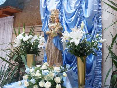 Qui, di fronte al civico 15, � stato infatti allestito un altarino decorato da lunghi drappeggi azzurri, con una tela e una statuetta della Madonna